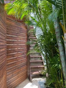 a wooden fence with a wooden gate and palm trees at La Terrasse des manguiers in Saint-Denis