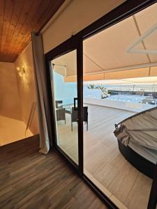 Cette chambre dispose d'une porte coulissante en verre offrant une vue sur l'océan. dans l'établissement Casa Uwe, El Remo, à Puerto Naos