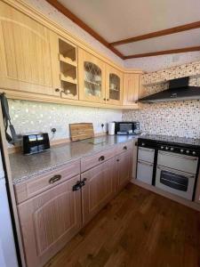 a kitchen with wooden cabinets and a counter top at Valley View Lodge in Welshpool
