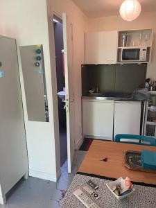 a small kitchen with a table and a counter top at charmant studio sous les toits de Paris in Paris