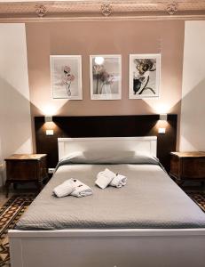 een slaapkamer met een bed met twee handdoeken erop bij Nova Roma Guest House in Rome