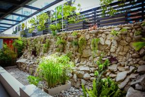 un muro di pietra con delle piante sopra di Urban Park Suites a Kigali
