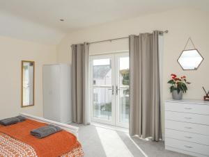 a bedroom with a bed and a sliding glass door at Maenan in Criccieth