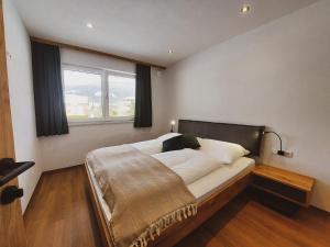 sypialnia z łóżkiem i dużym oknem w obiekcie Appartement Waldplatzl w mieście Altenmarkt im Pongau