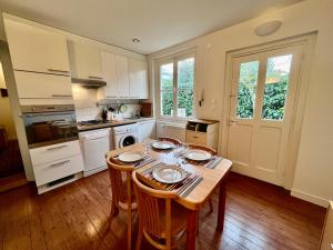 a kitchen with a wooden table with chairs and a dining room at L'Annexe Apparthôtel du 8, 3 étoiles in Besançon