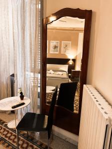 ローマにあるNova Roma Guest Houseの鏡、テーブル、ベッドが備わる客室です。