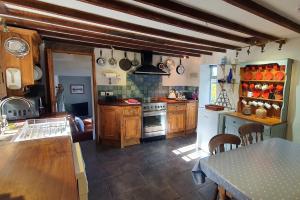 a kitchen with wooden cabinets and a stove top oven at Westdale Cottage, Elton in the Peak District in Elton
