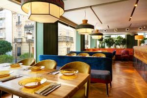 een restaurant met een houten tafel en stoelen bij Hotel Inglaterra in Sevilla