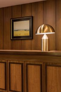 a lamp on a wooden wall with a picture at Hotel Emporda in Figueres