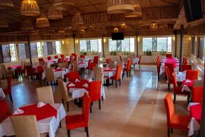 un restaurante con mesas y sillas rojas y blancas en Urban Park Suites, en Kigali