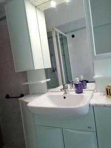 a white bathroom with a sink and a mirror at A casa di Fabio in Biella +17 photos