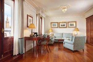 a living room with a couch and a table and chairs at Hotel Inglaterra in Seville