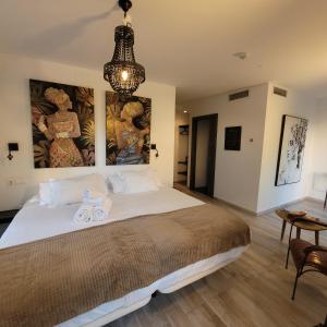 a bedroom with a large bed and a chandelier at Terrace Costa Hotel in Fuengirola