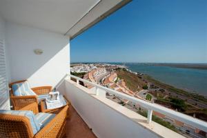 a balcony with chairs and a view of the ocean at Parador de Ayamonte in Ayamonte
