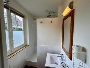 a bathroom with a sink and a mirror and a window at L'Annexe du 8 in Besançon