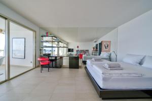 a bedroom with a large bed and a red chair at SUNNY in Villeneuve-Loubet