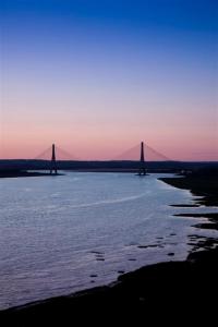 two bridges over a large body of water at sunset at Parador de Ayamonte in Ayamonte