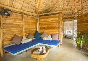 a room with a blue couch in a wooden room at Gal Oya Lodge in Galgamuwa