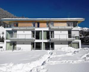 a white building with snow in front of it at Chalet Schloßkopf FeWo Rendl in Sankt Anton am Arlberg