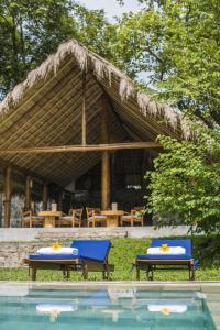 a pavilion with two chairs and a swimming pool at Gal Oya Lodge in Galgamuwa