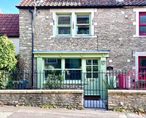 a house with a green door and a fence at Apple Cottage - Central Frome - Outdoor Space in Frome