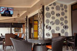ein Restaurant mit einem Tisch, Stühlen und einer Wand in der Unterkunft Urban Park Suites in Kigali