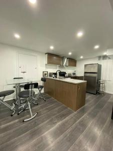 a kitchen with a table and chairs and a refrigerator at Adorable Quiet Open Concept Private Studio Suite in Ajax