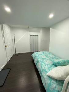 a bedroom with a bed with a green comforter at Adorable Quiet Open Concept Private Studio Suite in Ajax