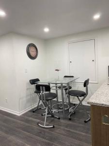 a dining room with a glass table and chairs at Adorable Quiet Open Concept Private Studio Suite in Ajax