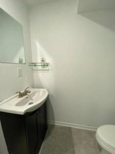 a white bathroom with a sink and a toilet at Adorable Quiet Open Concept Private Studio Suite in Ajax