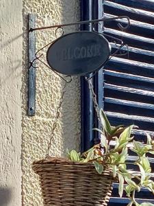 ein Korb mit einem Schild an der Wand mit einer Pflanze in der Unterkunft Le clos du marronnier in Rivières-les-Fosses