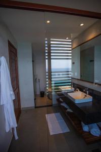 La salle de bains est pourvue d'un lavabo et d'un grand miroir. dans l'établissement Pousada Ecológica Akanã, à Fernando de Noronha