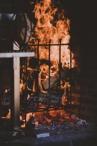 Ein Feuer brennt in einem Kamin in der Unterkunft Kläpphagen Koster in Sydkoster