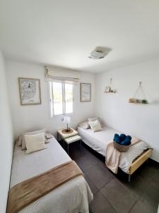 2 Betten in einem Zimmer mit weißen Wänden in der Unterkunft Endless Summer in San Bartolomé de Tirajana