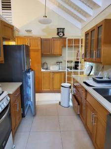 eine Küche mit Holzschränken und einem schwarzen Kühlschrank in der Unterkunft Vacation Home at The Palms Richmond in Richmond