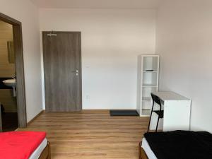 een kamer met een slaapkamer met een deur en een houten vloer bij FUNARENA CHEB 