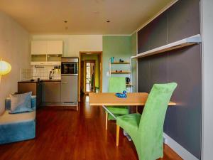 a kitchen with a wooden table and green chairs at Serviced Apartement Xanthurus in Schwelm