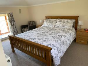 a bedroom with a large bed and a chair at The Dairy in Bagillt
