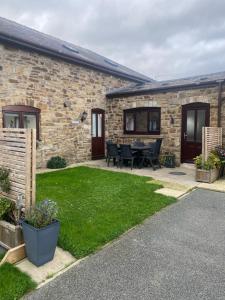 a stone house with a patio and a yard at The Dairy in Bagilt