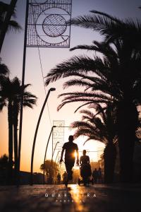 two people riding motorcycles on a street at sunset at Nautic in Quarteira