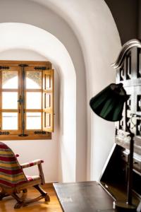 ビジャルバにあるパラドール デ ビラルバのデスク、椅子、窓が備わる客室です。