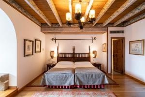 a bedroom with a large bed and a wooden ceiling at Parador de Vilalba in Villalba