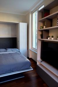 ein Schlafzimmer mit einem Bett und einem Flachbildfernseher in der Unterkunft Monolocale di pregio Palazzo dei Rolli in Genua + 21 Fotos