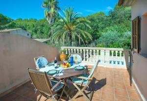 a wooden table and chairs on a balcony with a table and chairsktop at Owl Booking Villa Irina - 2 Min Walk To The Old Town in Pollença