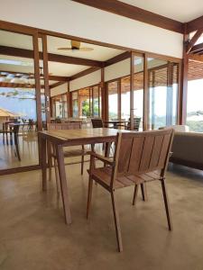 uma sala de jantar com uma mesa de madeira e cadeiras em Pousada Ecológica Akanã em Fernando de Noronha