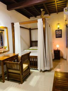 a bedroom with a bed and a desk and a chair at Mother's Inn Homestay in Cochin