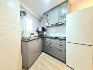 豐希羅拉的住宿－AA Guest - Sol Eco Apartment Lateral Sea Views，厨房配有不锈钢用具和白色冰箱