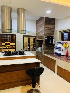 a large kitchen with wooden counters and a black stool at Mother's Inn Homestay in Cochin