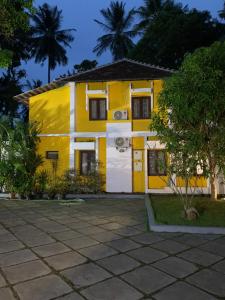 a yellow and white house with a yard at Mother's Inn Homestay in Cochin