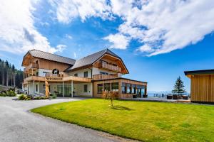 a large house with a green lawn in front of it at Familienhotel Petschnighof in Diex